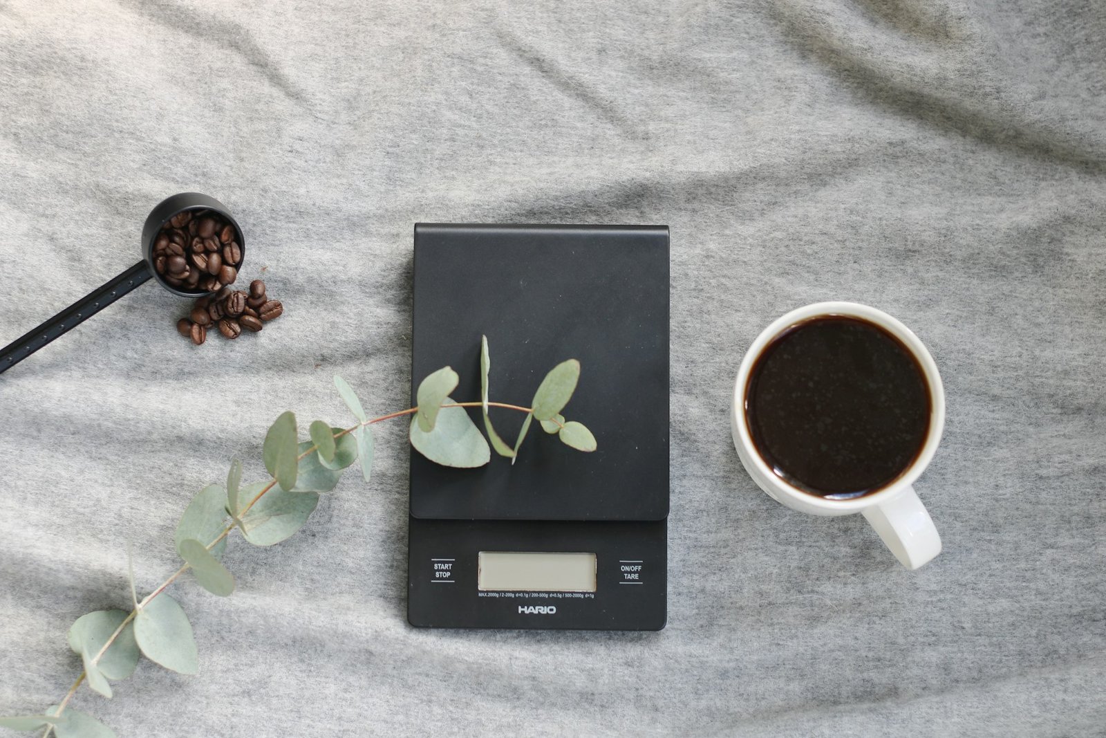 Coffee scale beside a cup of coffee, illustrating the Shot and Scale affiliate disclosure for espresso gear links