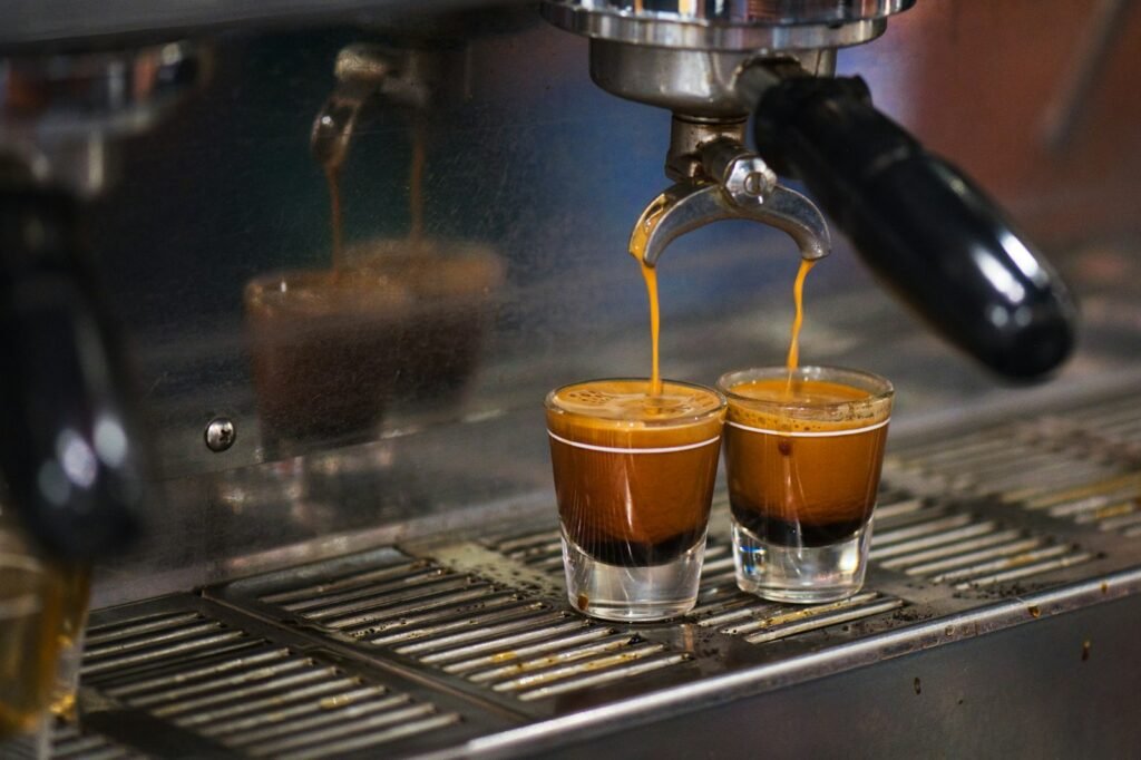 Two espresso shots pouring into glasses from a double-spout portafilter