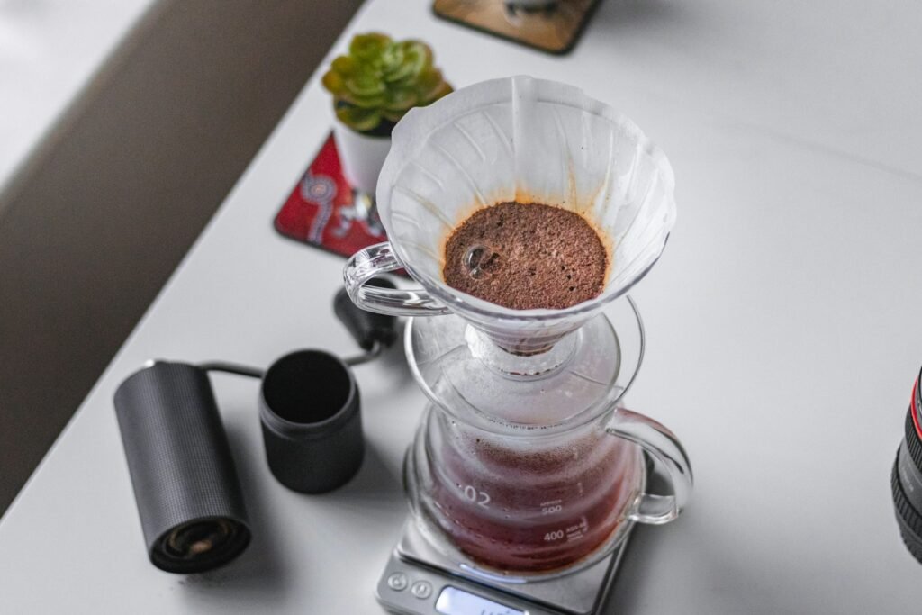 Choosing a hand grinder for espresso: a black hand grinder beside a pour-over brewer