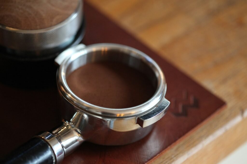 Stainless steel portafilter with tamped coffee; your Breville portafilter size decides which accessories fit